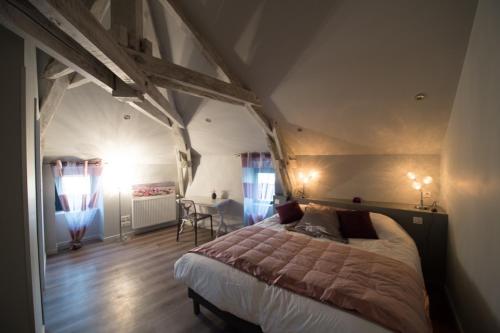 a bedroom with a bed and a table in it at Gite De Charme Caussenard in Le Massegros