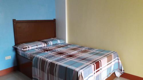 a bedroom with a bed with a striped bedspread at Mayon Lodging House in Legazpi