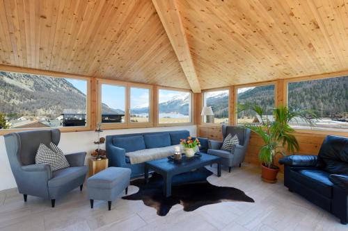 a living room with blue couches and a table at Hotel Cervo in Sils Maria