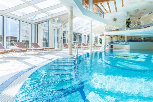 a swimming pool in a house with glass walls at Hotel Neue Post in Hippach