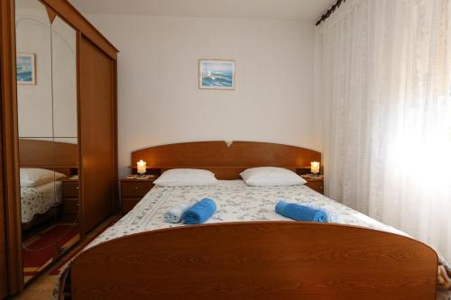a bedroom with a bed with blue slippers on it at Apartment MIHAJIC M in Klimno