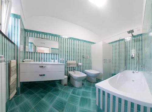 a bathroom with a tub and a toilet and a sink at Casa Rosanna in Maiori
