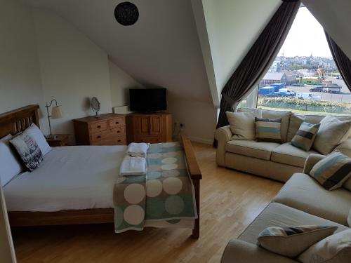 a bedroom with a large bed and a couch at Portrush Seaview Apartments in Portrush