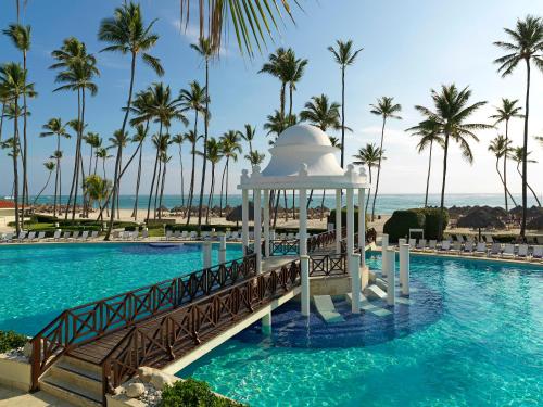 a resort pool with a gazebo and palm trees at Paradisus Palma Real Golf & Spa Resort All Inclusive in Punta Cana