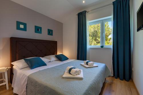 a bedroom with a bed with two towels on it at Apartments Solmar in Podstrana