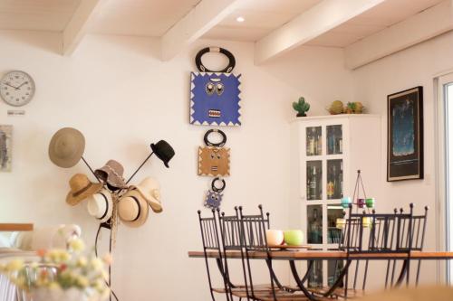 a room with a table and chairs and clocks on the wall at Les Chambres d'Hôtes du Grand Mornas in Carry-le-Rouet