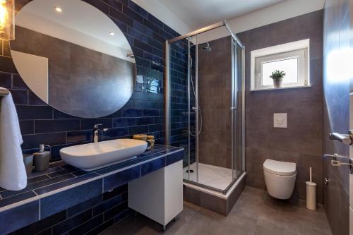 a bathroom with a sink and a shower and a toilet at Apartments Solmar in Podstrana