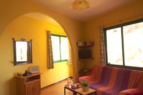 uma sala de estar com um sofá e duas janelas em Apartamentos Nayara em Valle Gran Rey