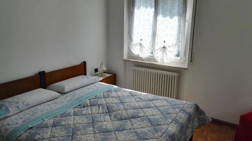 a bedroom with a bed and a window at Villa Ginestra in Molveno