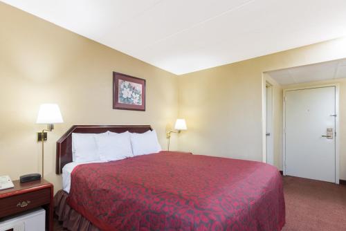 a hotel room with a bed with a red bedspread at Days Inn by Wyndham Hagerstown I-70 in Hagerstown