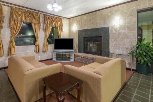 a living room with two couches and a television at Days Inn by Wyndham Hagerstown I-70 in Hagerstown