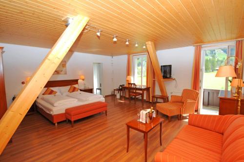 a living room with a bed and a staircase at Belle Epoque Hotel Victoria & Apartments in Kandersteg