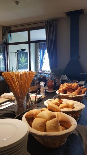 a table with two baskets of bread on it at Hotel Cardamomo Sigüenza in Carabias