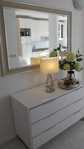 a white dresser with a lamp and a mirror at Sa Maniga 6 O Apartment Stephanie in Cala Millor