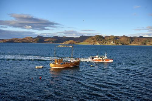 two boats floating in a large body of water at Crinan Hotel in Crinan