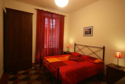 1 dormitorio con cama roja y cortina roja en Tatusa al Colosseo, en Roma
