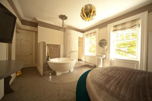 a large bathroom with a tub and a bed at Kilmore Country House in Glenariff
