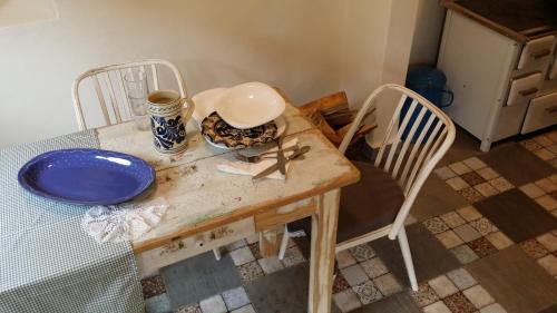 a table with two chairs and a blue plate on it at Helló Bogács in Bogács