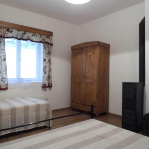 a bedroom with a bed and a cabinet and a window at Helló Bogács in Bogács