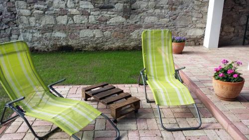 two green chairs and a bench on a patio at Helló Bogács in Bogács
