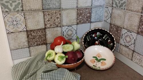 a counter with two baskets of fruits and vegetables at Helló Bogács in Bogács