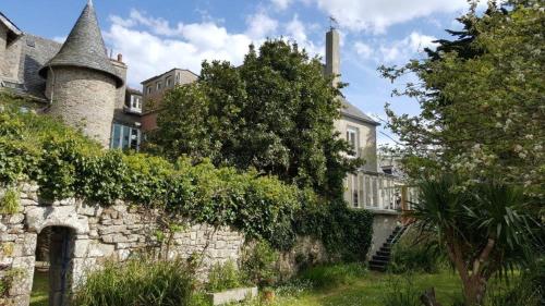 an old stone building with a tree in front of it at Hotel D'Angleterre in Roscoff