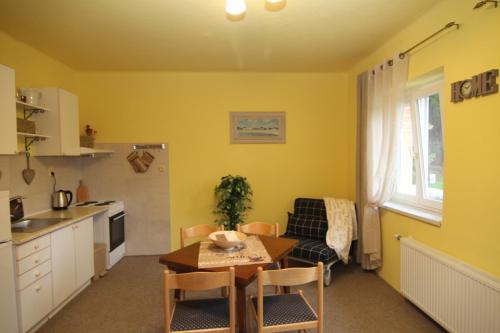 a kitchen and living room with a table and a dining room at Chata Javorina in Javorník