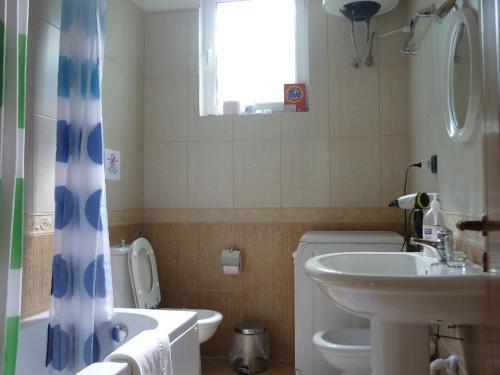 ein Bad mit einem Waschbecken, einem WC und einem Fenster in der Unterkunft Villa Basilika in Vlorë