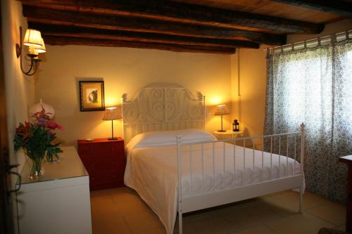 um quarto com uma cama branca e duas mesas de cabeceira em Quinta da Raposeira em Armamar