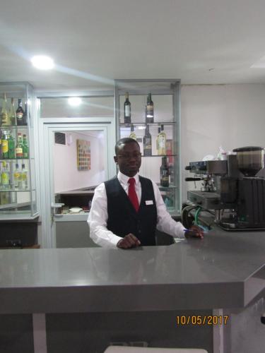 a man in a suit and tie standing behind a counter at Hotel Excelsior in Lisbon