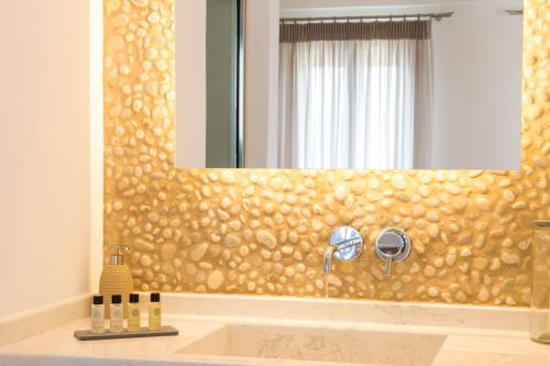 a bathroom with a mirror and a sink at Louis Studios Santorini in Kamari