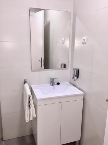 a white bathroom with a sink and a mirror at SolRoom (plz. La Nogalera) in Torremolinos