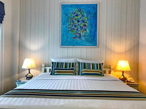 a bedroom with a large bed with two lamps at Casa Blanca Boutique Hotel - SHA Plus in Phuket Town