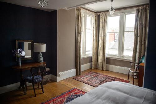 a bedroom with a bed and a table and a mirror at Bank House B&B in Bishops Castle