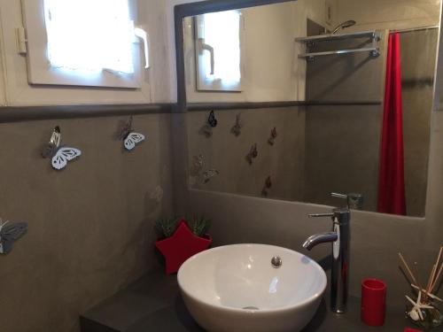a bathroom with a white sink and a shower at La Petite Maison sur l'Ile de Ré in La Flotte