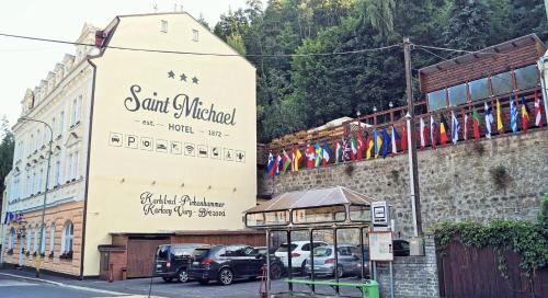a building with a sign on the side of it at Hotel St.Michael in Karlovy Vary