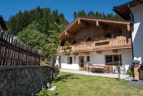 a house with a balcony and a wooden fence at Landhaus & Apartment Taxach in Ried im Zillertal