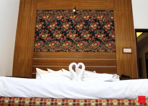 a bed with two white towels on top of it at Nagar Valley Hotel Ltd. in Dhaka