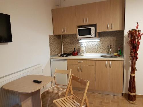 a small kitchen with a table and chairs and a microwave at Casa Rezidentiala Aria in Cluj-Napoca