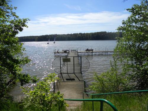 a dock on a lake with boats in the water at Apartament Makowo in Makowo