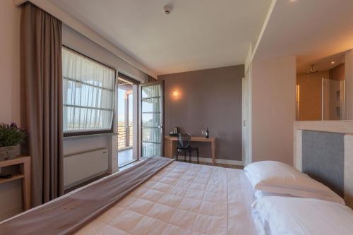 a bedroom with a large bed and a desk at Podere del Priorato in Albinia
