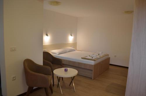 Habitación con cama, mesa y sillas. en Apartments TMV Dragovic en Sveti Stefan