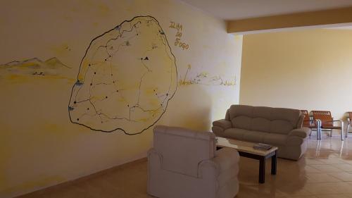 a living room with two couches and a drawing on the wall at Hotel Ocean View & Restaurante Seafood in São Filipe