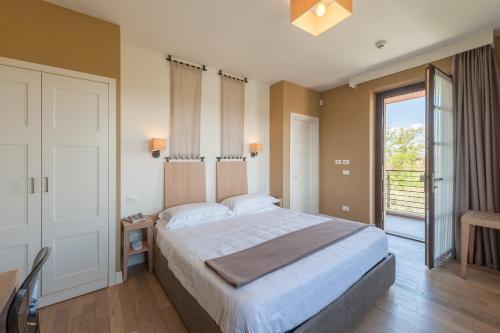 a bedroom with a large bed and a large window at Podere del Priorato in Albinia