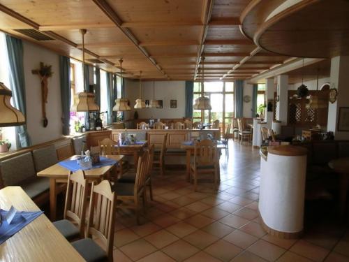 a restaurant with wooden tables and chairs in a room at Hotel-Restaurant Kreuzhuber in Neuburg am Inn