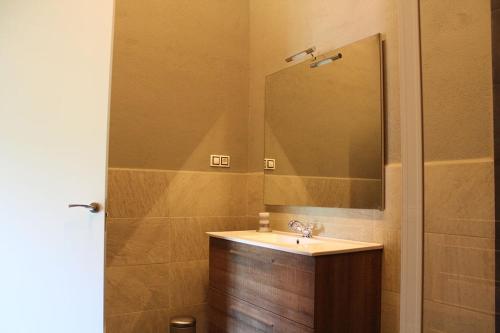 uma casa de banho com um lavatório e um espelho em Casanova de Baix em Ripoll