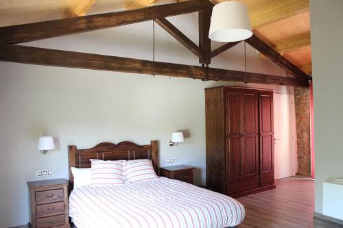 1 dormitorio con cama y techo de madera en Casanova de Baix en Ripoll