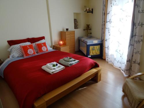 ein Schlafzimmer mit einem roten Bett mit zwei Handtüchern darauf in der Unterkunft Alfama 28 Tram in Lissabon