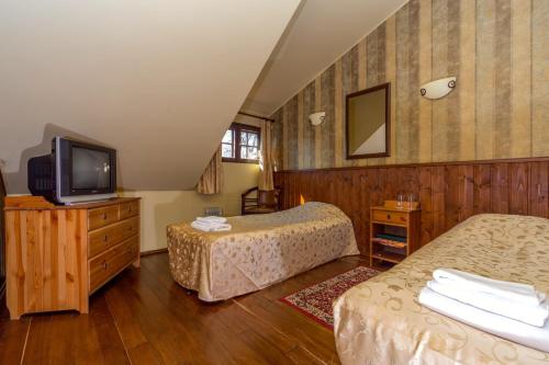 Viimsi manor guesthouse Birgitta في تالين: غرفة فندقية بسريرين وتلفزيون