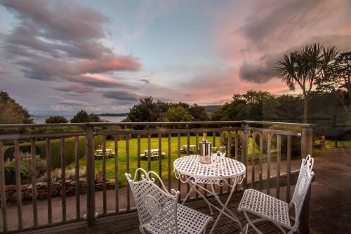 a table and two chairs on a balcony with a table and chairs at The Arran Lodge & Arran Sleep Huts in Lamlash